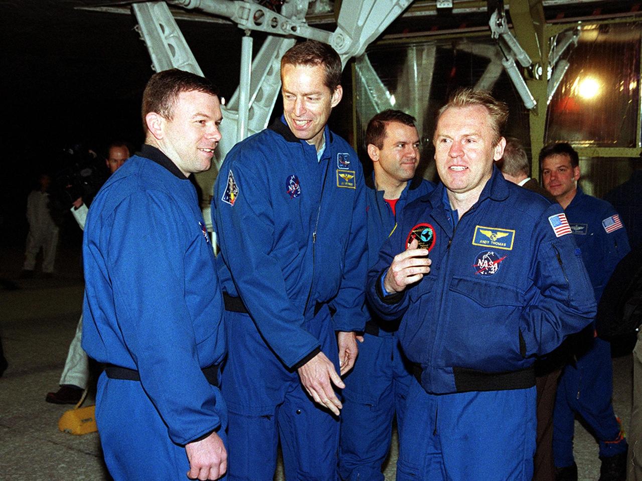 After exiting the Crew Transport Vehicle, the STS-102 crew gathers under Discovery for a walk-around. From left are Pilot James Kelly, Commander James Wetherbee and Mission Specialists Paul Richards and Andrew Thomas. . The crew landed at the KSC Shuttle Landing Facility at 2:31 a.m. EST aboard Discovery following a 12-day, 19-hour, 49-minute mission to the International Space Station