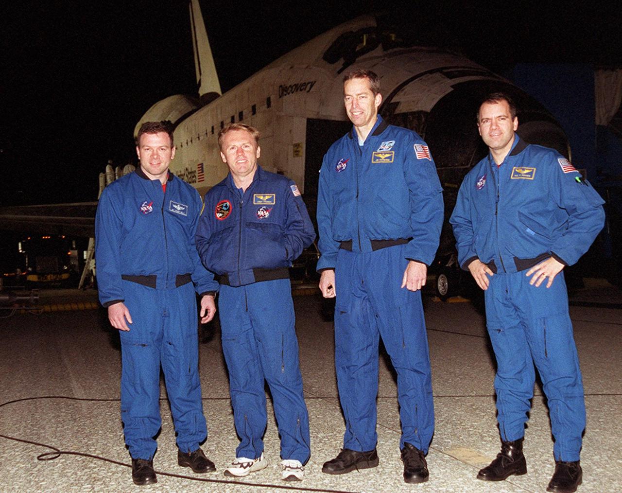 After exiting the Crew Transport Vehicle, the STS-102 crew gathers under Discovery for a walk-around. From left are Pilot James Kelly, Mission Specialist Andy Thomas, Commander James Wetherbee and Mission Specialist Paul Richards. The crew landed at the KSC Shuttle Landing Facility at 2:31 a.m. EST aboard Discovery following a 12-day, 19-hour, 49-minute mission to the International Space Station