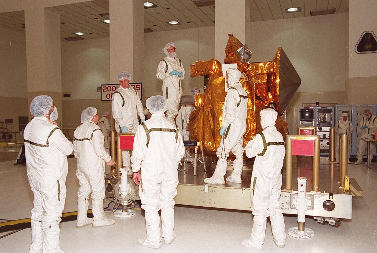 Workers in the Space Assembly and Encapsulation Building 2 prepare to move the 2001 Mars Odyssey Orbiter to the spin table for testing. The orbiter carries three science instruments THEMIS, the Gamma Ray Spectrometer (GRS), and the Mars Radiation Environment Experiment (MARIE) that will map the mineralogy and morphology of the Martian surface, the elemental composition of the surface and determine the abundance of hydrogen in the shallow subsurface, and characterize aspects of the near-space radiation environment with regards to the radiation-related risk to human explorers. The Mars Odyssey Orbiter is scheduled for launch on April 7, 2001, aboard a Delta II rocket from Launch Pad 17-A, Cape Canaveral Air Force Station