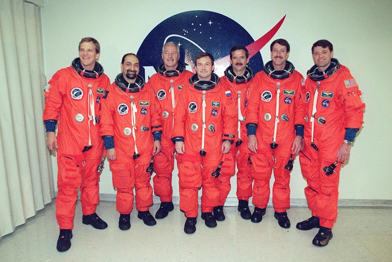 The STS-100 crew pauses for a photo before walkout and the ride to Launch Pad 39A for a simulated countdown. Standing, from left, are Mission Specialists Scott E. Parazynski, Umberto Guidoni, John L. Phillips, Yuri V. Lonchakov and Chris A. Hadfield; Commander Kent V. Rominger; and Pilot Jeffrey S. Ashby. The STS-100 crew is at KSC for Terminal Countdown Demonstration Test activities that include emergency escape training at the pad and the simulated launch countdown. The mission is carrying the Multi-Purpose Logistics Module Raffaello and the SSRMS, to the International Space Station. Raffaello carries six system racks and two storage racks for the U.S. Lab. The SSRMS is crucial to the continued assembly of the orbiting complex. Launch of mission STS-100 is scheduled for April 19 at 2:41 p.m. EDT from Launch Pad 39A