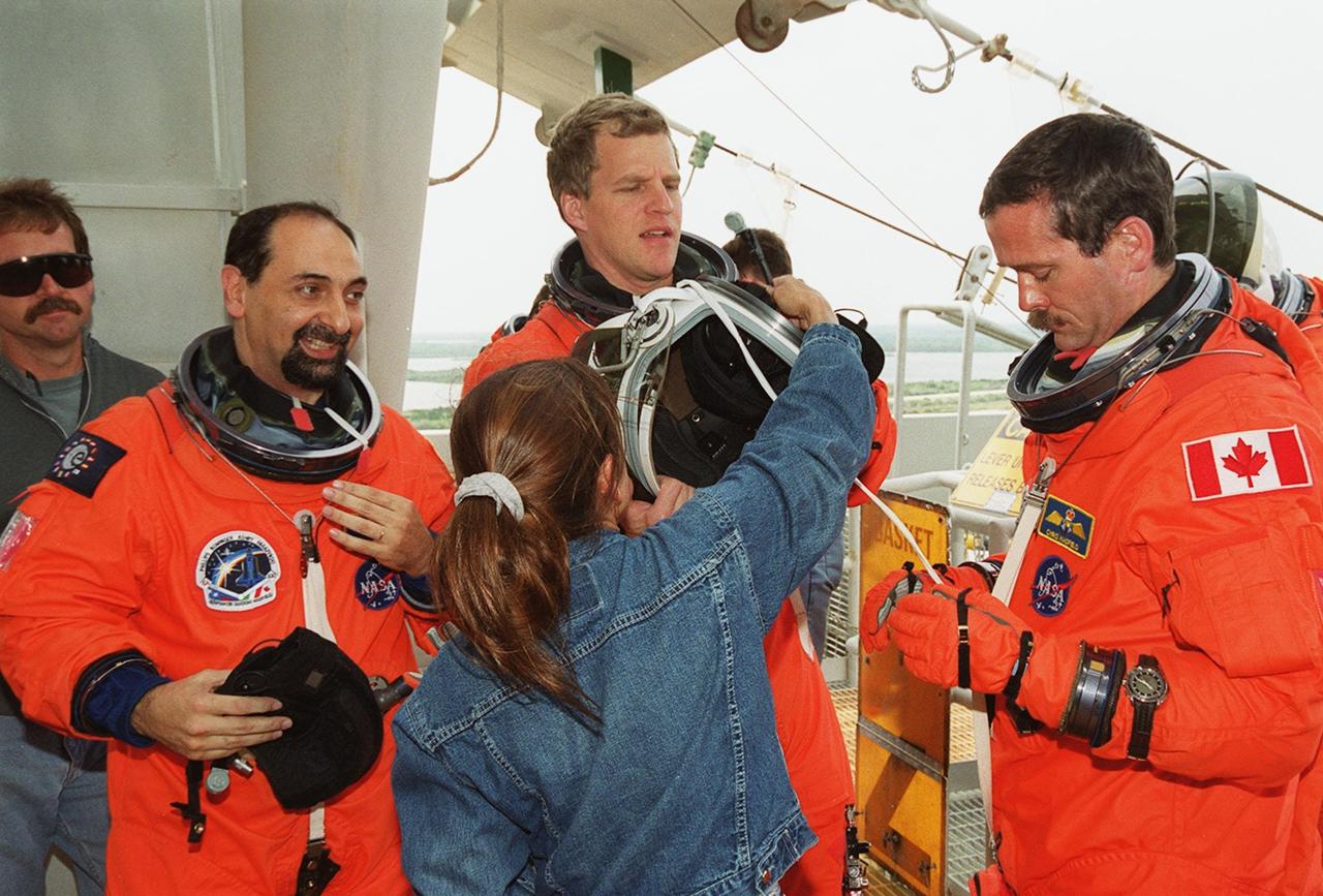 KENNEDY SPACE CENTER, FLA. -- STS-100 Mission Specialists Umberto Guidoni (left), Scott E. Parazynski (center) and Chris A. Hadfield (right) conclude emergency escape training at Launch Pad 39A. Parazynski gets help with his helmet. The crew is taking part in Terminal Countdown Demonstration Test activities that also include a simulated launch countdown. The mission is carrying the Multi-Purpose Logistics Module Raffaello and the SSRMS, to the International Space Station. Raffaello carries six system racks and two storage racks for the U.S. Lab. The SSRMS is crucial to the continued assembly of the orbiting complex. Launch of mission STS-100 is scheduled for April 19 at 2:41 p.m. EDT from Launch Pad 39A