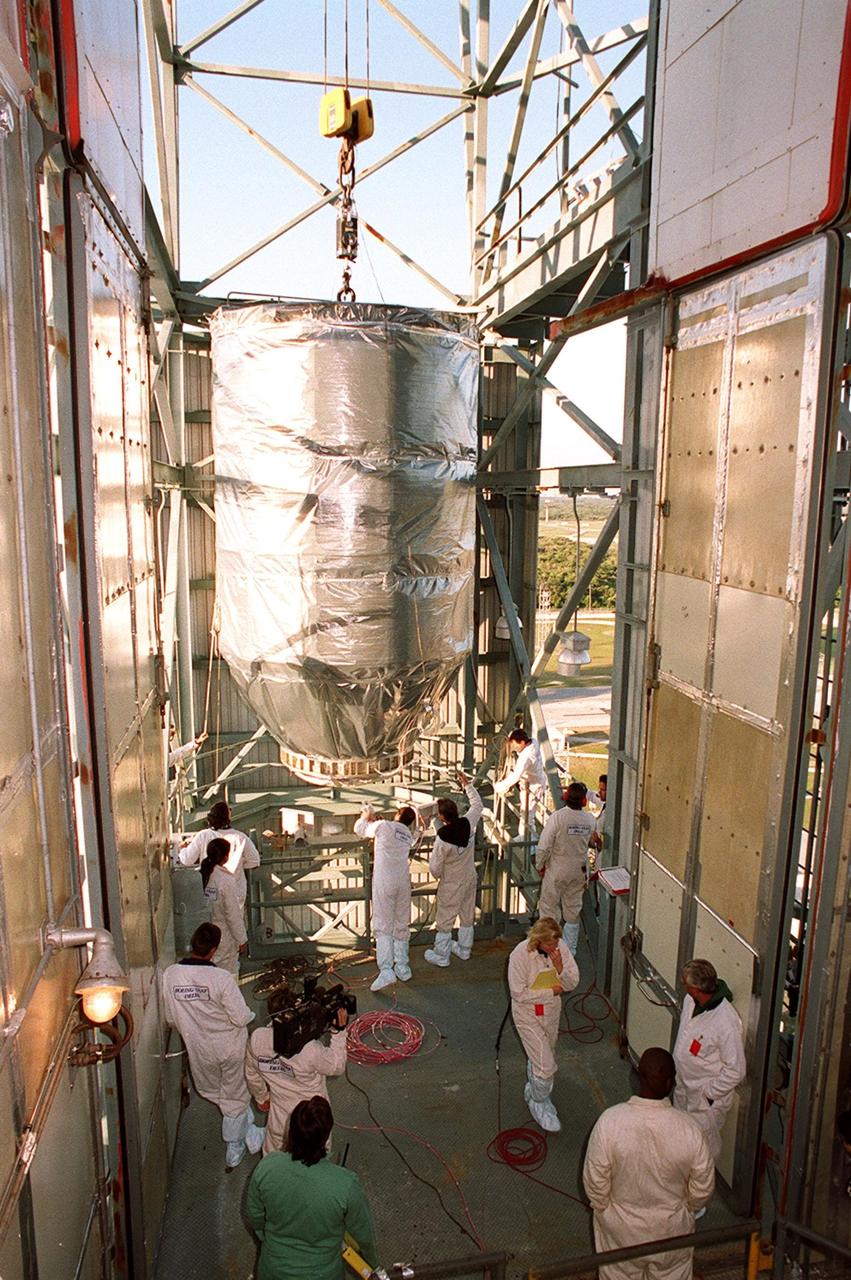 Workers on Launch Pad 17-A, Cape Canaveral Air Force Station, get ready to move the Mars Odyssey spacecraft into the clean room at the top of the gantry. There it will be mated encased by the fairing of the Delta II rocket already in place. The spacecraft will map the Martian surface in search of geological features that could indicate the presence of water, now or in the past, and may contribute significantly toward understanding what will be necessary for a more sophisticated exploration of Mars. Launch is scheduled for 11:02 a.m. EDT April 7