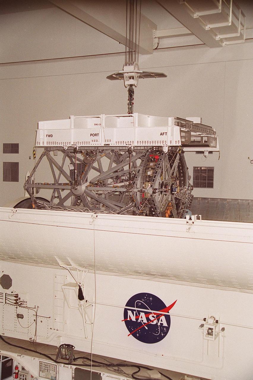 KENNEDY SPACE CENTER, FLA. -- In the Space Station Processing Facility, an overhead crane lifts the P3 Integrated Truss Structure out of the payload canister that transferred it from the Operations and Checkout Building. The port-side P3 truss is scheduled to be added to the International Space Station on mission STS-115 in 2002 aboard Space Shuttle Atlantis. The P3 will be attached to the first port truss segment, P1, being installed in an earlier mission.