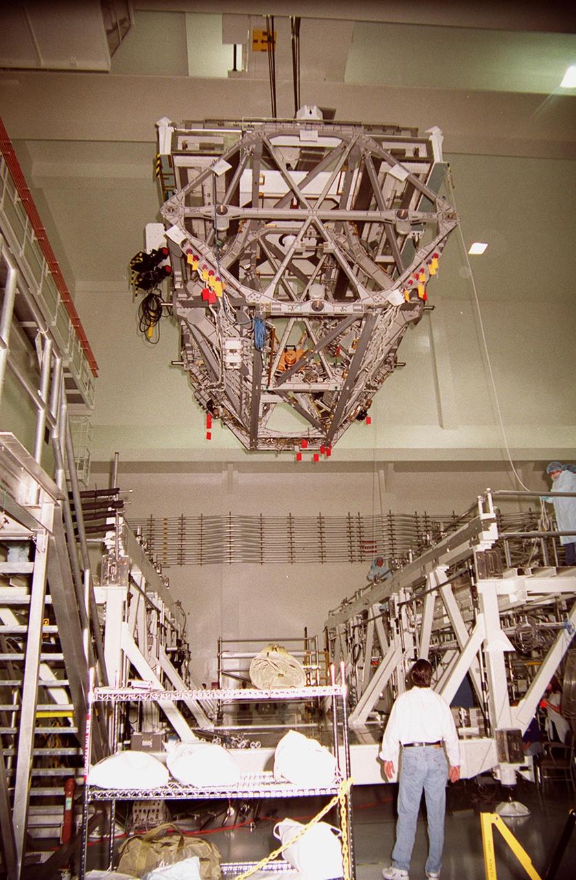 KENNEDY SPACE CENTER, FLA. -- In the Space Station Processing Facility, an overhead crane carrying the P3 Integrated Truss Structure moves into place over a workstand where it will deposit the truss. The port-side P3 truss is scheduled to be added to the International Space Station on mission STS-115 in 2002 aboard Space Shuttle Atlantis. The P3 will be attached to the first port truss segment, P1, being installed in an earlier mission