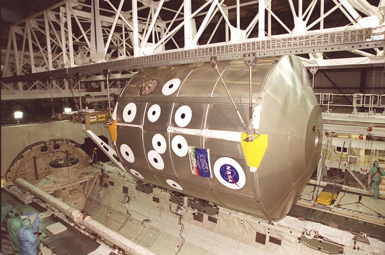 KENNEDY SPACE CENTER, FLA. -- In the Orbiter Processing Facility bay 2, an overhead crane lifts the Multi-Purpose Logistics Module Leonardo and the integrated cargo carrier behind it out of Discovery’s payload bay. The MPLM has just returned from its first round trip to the International Space Station on mission STS-102. Leonardo will be transferred to the SSPF to prepare it for future missions. The MPLM serves as a cargo van, carrying equipment and supplies to the Space Station