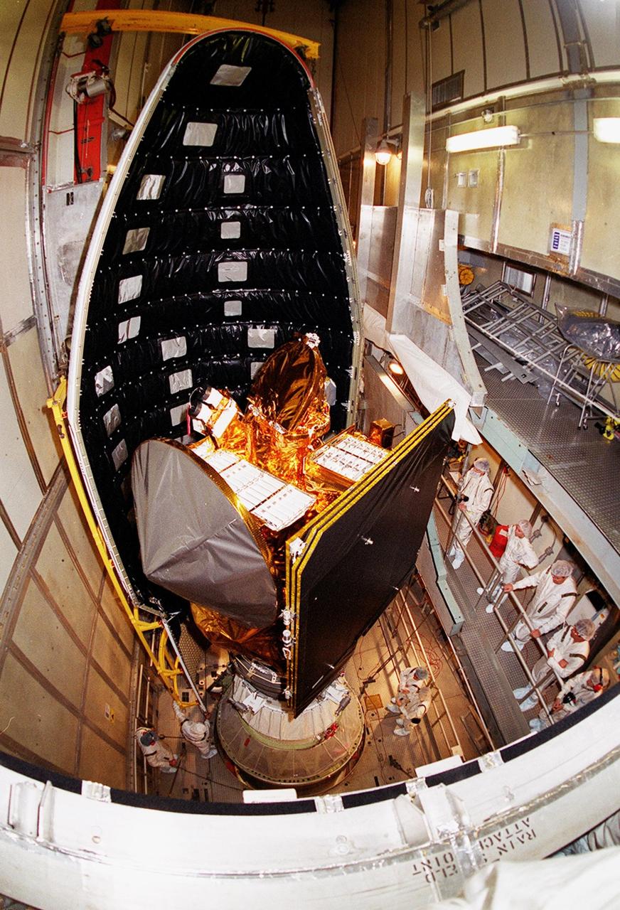 At Launch Complex 17-A, Cape Canaveral Air Force Station, workers stand by as a piece of the Delta rocket fairing is moved into place around the Mars Odyssey spacecraft. NASA’s latest explorer carries three scientific instruments to map the chemical and mineralogical makeup of Mars: a thermal-emission imaging system, a gamma ray spectrometer and a Martian radiation environment experiment. The imaging system will map the planet with high-resolution thermal images and give scientists an increased level of detail to help them understand how the mineralogy of the planet relates to the land forms. In addition, Odyssey will serve as a communications relay for U.S. and international landers arriving at Mars in 2003/2004. The Mars Odyssey is scheduled for launch aboard a Delta II rocket April 7, 2001, at 11:02 a.m. EST
