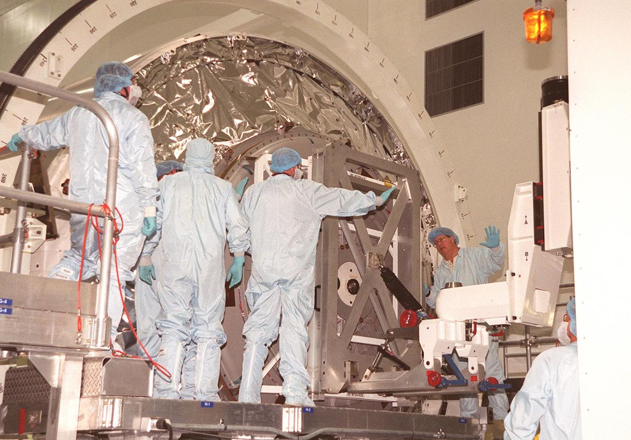 KENNEDY SPACE CENTER, FLA. -- Workers in the Space Station Processing Facility prepare to remove the hatch on Multi-Purpose Logistics Module Leonardo. The MPLM has just returned from its maiden voyage to the International Space Station aboard Discovery on mission STS-102. Leonardo is one of three MPLMs built by the Italian Space Agency to serve as “cargo vans” to the Station, carrying supplies and equipment. In the SSPF, Leonardo will be prepared for a future mission