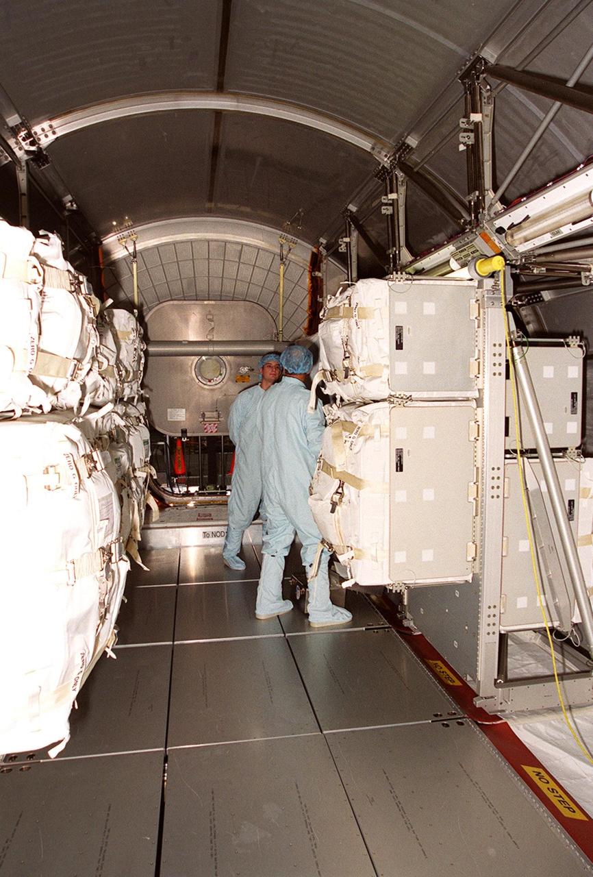 KENNEDY SPACE CENTER, FLA. -- Workers in the Space Station Processing Facility are able to enter the Multi-Purpose Logistics Module Leonardo to begin removing the contents. The MPLM has just returned from its maiden voyage to the International Space Station aboard Discovery on mission STS-102. It has brought back to KSC nearly a ton of trash and excess equipment from the Space Station. Leonardo is one of three MPLMs built by the Italian Space Agency to serve as “cargo vans” to the Station, carrying supplies and equipment. In the SSPF, Leonardo will be prepared for a future mission