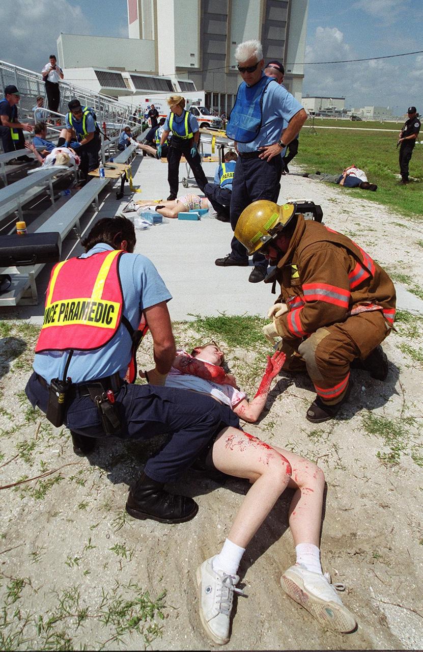 KENNEDY SPACE CENTER, FLA. -- During a staged mass casualty exercise in the Launch Complex 39 area, a paramedic checks an injured woman on the ground. Employees are playing the role of victims during a sniper scenario. The exercise is being staged to validate capabilities of KSC’ fire, medical, helicopter transport and security personnel to respond to such an event.