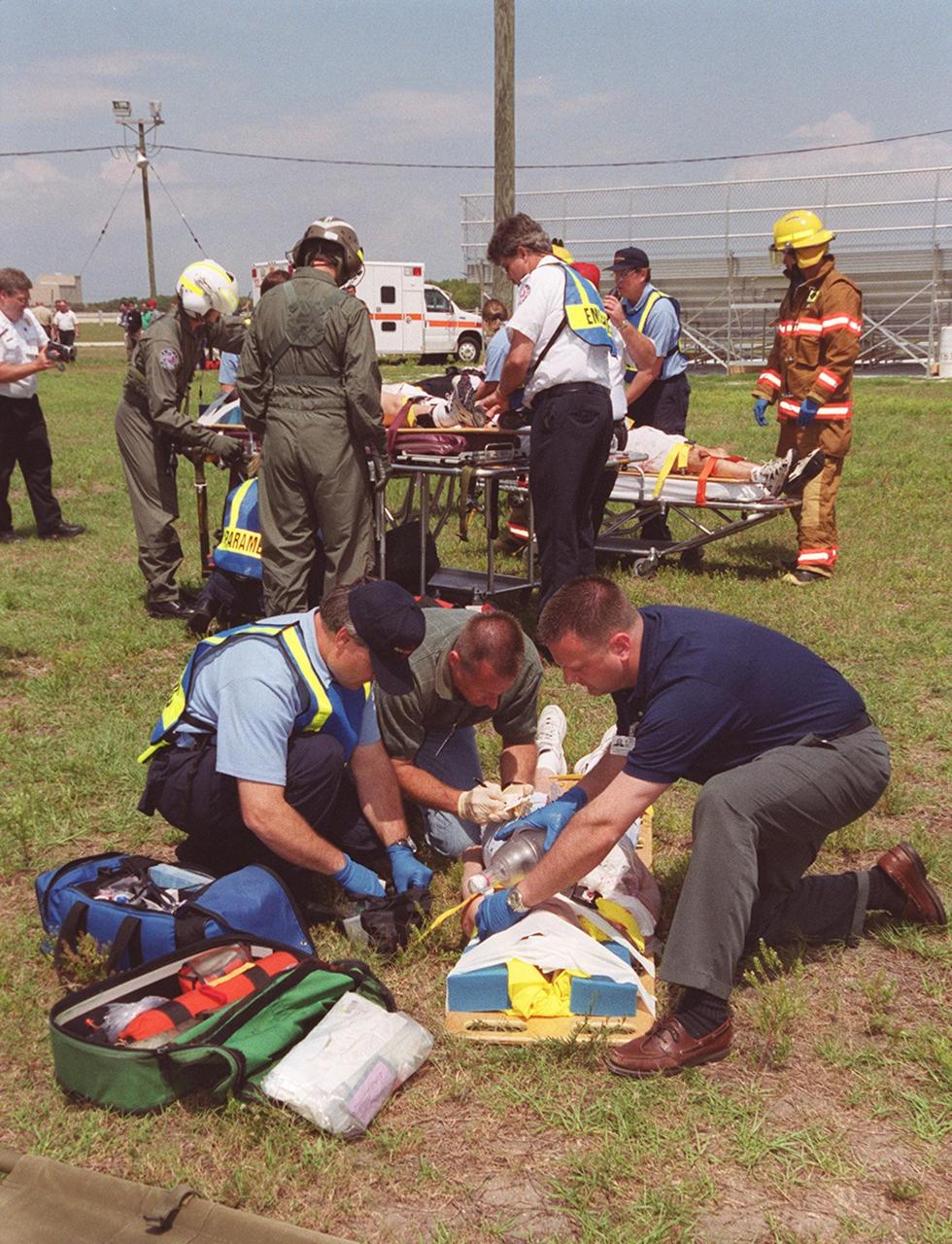 KENNEDY SPACE CENTER, FLA. -- Medical, paramedic and other personnel attend to role-playing “victims” on the grass in the Launch Complex 39 area. It is the site of a staged mass casualty exercise designed to validate capabilities of KSC’s fire, medical, helicopter transport and security personnel to respond to an event such as this fictitious sniper attack