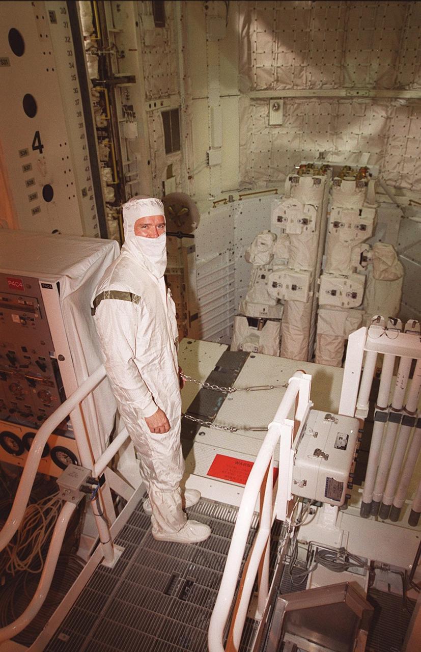 STS-100 Mission Specialist Chris A. Hadfield, who is with the Canadian Space Agency, pauses for the photographer while looking over part of the mission payload, the Canadian robotic arm (SSRMS). The SSRMS is capable of handling large payloads and assisting with docking the Space Shuttle. It is crucial to the continued assembly of the International Space Station. Hadfield and the rest of the crew are at KSC to complete Terminal Countdown Demonstration Test activities that were postponed earlier. The TCDT includes emergency escape training, payload bay walkdown, and a simulated launch countdown. The primary payload also includes Multi-Purpose Logistics Module, Raffaello. Launch of Space Shuttle Endeavour on mission STS-100 is targeted for April 19 at 2:41 p.m. EDT from Launch Pad 39A