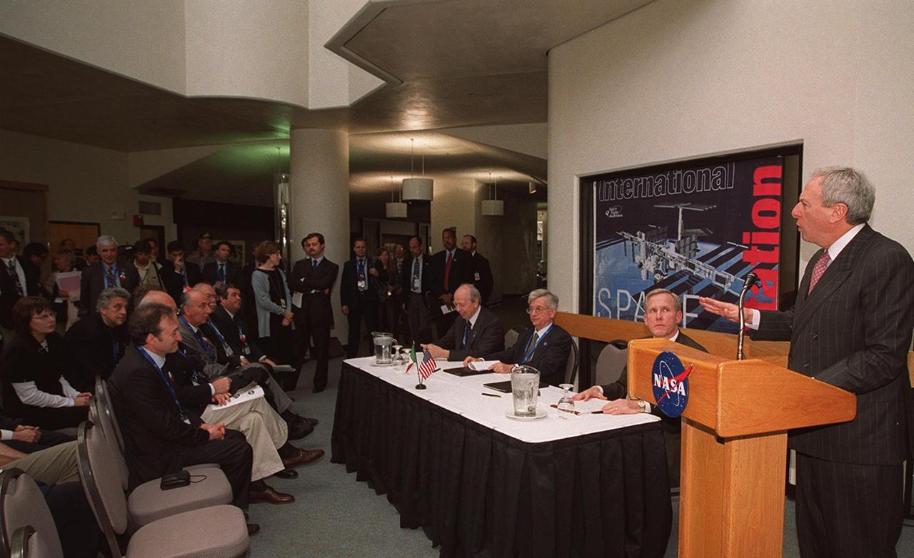 At a signing ceremony between the Italian Space Agency (ASI) and NASA for a Framework for Cooperation to build the Habitation Module for the International Space Station, NASA Administrator Daniel S. Goldin speaks to attendees. Seated at the table next to Goldin are The Honorable Lamberto Dini, Minister of Foreign Affairs, Republic of Italy (far left), Italian Space Agency President Sergio DeJulio, and John Schumacher, assistant administrator, NASA External Relations. The Framework is a potential bilateral cooperative agreement that could result in ASI development of a U.S. Habitation Module for the International Space Station. This agreement allows the U.S. to explore an alternative approach to achieve full crew habitation for the ISS. A Memorandum of Understanding (MOU) between NASA and ASI will be required to formally document NASA and ASI’s respective responsibilities in a legally binding document. The Framework signed today would form the basis for a potential MOU which NASA and ASI would sign after completion of the program assessment and subsequent negotiations.The ceremony took place at the IMAX Theater, Kennedy Space Center Visitor Complex