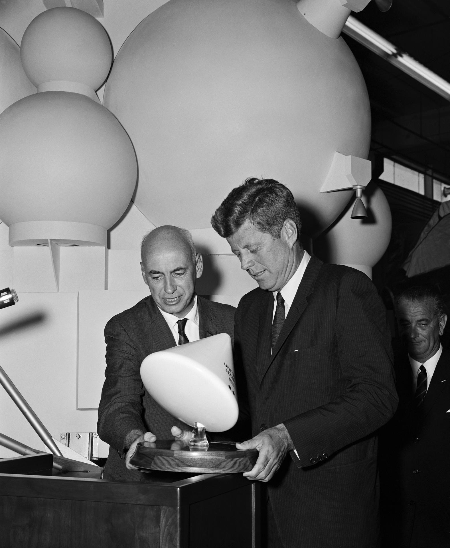 Former Johnson Center Director Dr. Robert R. Gilruth (left) and President John F. Kennedy looking at a small model of the Apollo Command Module.