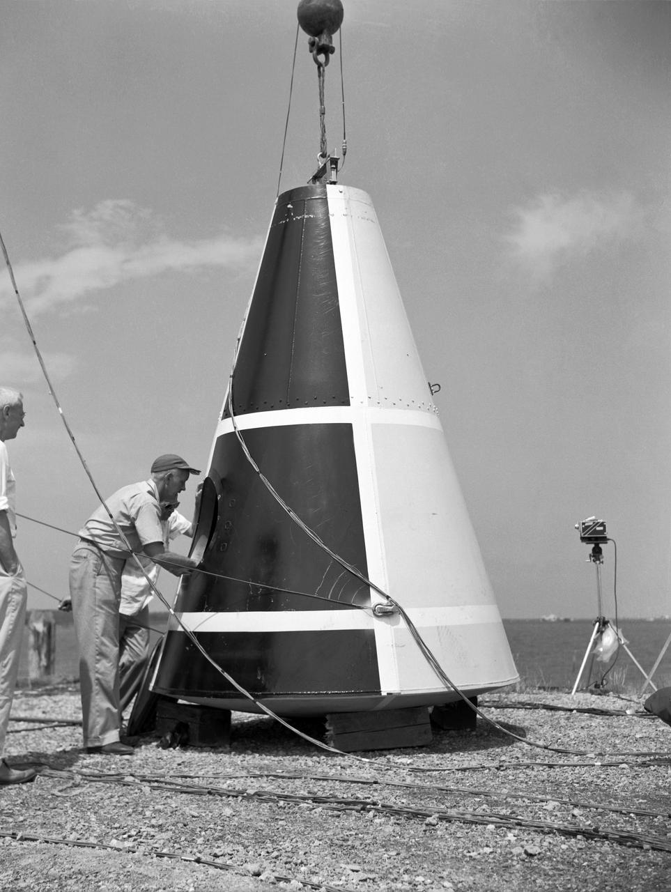  Photographed on: 08 05 1958. -- Impact test conducted by Langley's Hydrodynamics Division. The Division conducted a series of impact studies with full scale and model capsules of the original capsule shape A. Joseph Shortal wrote (Vol. 3, p. 16):  The basic design of the capsule was made by M.A. Faget and his coworkers at PARD during the winter of 1957-1958. It was natural, then, that extensive use was made of the facilities at Wallops during the development of the spacecraft. The tests at Wallops consisted of 26 full-size capsules, either launched from the ground by rocket power or dropped from airplanes at high altitude and 28 scaled models, either rocket boosted or released from balloons. Emphasis in the Wallops program was on dynamic stability and aerodynamic heating of the capsule, and effectiveness of the pilot-escape and parachute-recovery systems. The biggest part of the Wallops program was the series of full-size capsules, rocket launched with the Little Joe booster, developed especially for Mercury.  -- Published in Joseph A. Shortal, History of Wallops Station: Origins and Activities Through 1949, (Wallops Island, VA: National Aeronautics and Space Administration, Wallops Station, nd), Comment Edition.