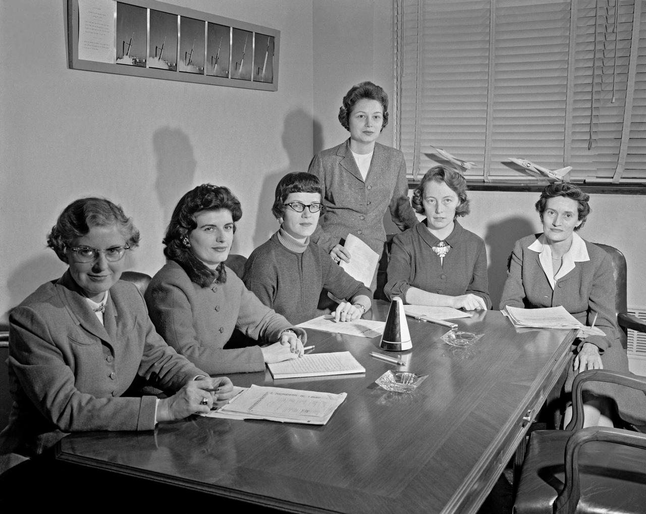 Women Scientists: Lucille Coltrane, Jean Clark Keating, Katherine Cullie Speegle, Doris 'Dot' Lee, Ruth Whitman, and Emily Stephens Mueller,Lucille Coltrane is at the far left. She was a computer and worked for Norm Crabill who provided positive identification. Lucille authored a NACA Research Memorandum, Investigation of Two Bluff Shapes in Axial Free Flight Over a Mach Number Range From 0.35 to 2.15 in 1958.  Next to Lucille is Jean Clark Keating. Jean was identified by Mary Woerner who said that both Jean and her husband Jerry are now deceased.  The third woman from the left is Katherine Cullie Speegle. Katherine co-authored two research papers: Preliminary Results From a Free-Flight Investigation of Boundary-Layer Transition and Heat Transfer on a Highly Polished 8-Inch-Diameter Hemisphere-Cylinder at Mach Numbers up to 3 and Reynolds Numbers Based on a Length of 1 Foot up to 17.7 x 10 to the 6th and Heat Transfer For Mach Numbers Up to 2.2 and Pressure Distributions for Mach Numbers Up to 4.7 From Flight Investigations of a Flat-Face Cone and a Hemisphere-Cone.  Norm remembered the woman standing as Doris. Mary Alice identified her as Doris 'Dot' Lee, who worked with Katherine Speegle. Dot was married to a NASA engineer named John Lee.  Next to Doris is Ruth Whitman. Norm remembered she and her husband owned a Howard DGA 15 at the airport in WEst Point. That prompted Mary Alice to remember her name and that her husband was Jim.  The woman seated on the right is Emily Stephens Mueller. Norm remembers that Emily went to Houston as part of the Space Task Group, but retired back here on the peninsula. In 2008, Emily attended the NACA Reunion X11. She walked over to a table of books about the history of NACA, former NACA facilities and the organization's aviation pioneers and saw a book about women of flight from the Dryden Research Center and paused, then pointed somewhat in amazement. "That’s me," she said of a picture on the cover of her on the far left of a li