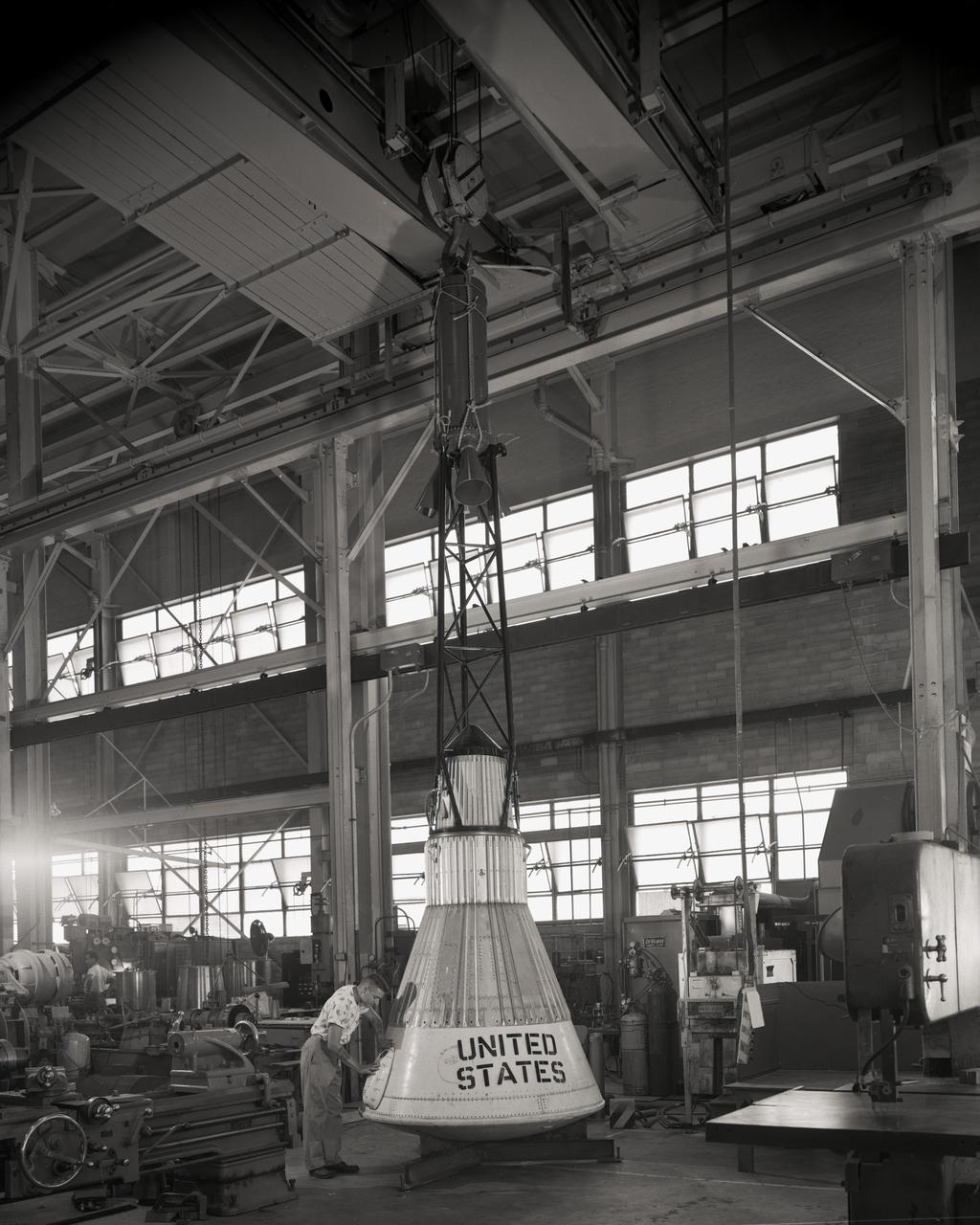 Assembling the Little Joe capsules.  The capsules were manufactured  in-house  by Langley technicians. Three capsules are shown here in various stages of assembly. The escape tower and rocket motors shown on the completed capsule would be removed before shipping and finally assembly for launching at Wallops Island. Joseph Shortal wrote (vol. 3, p. 32):  Design of the Little Joe capsules began at Langley before McDonnell started on the design of the Mercury capsule and was, therefore, a separate design. Although it was not designed to carry a man, it did have to carry a monkey. It had to meet the weight and center of gravity requirements of Mercury and withstand the same aerodynamic loads during the exit trajectory.   Although in comparison with the overall Mercury Project, Little Joe was a simple undertaking, the fact that an attempt was made to condense a normal two-year project into a 6-month one with in house labor turned it into a major undertaking for Langley.  Project Mercury: Little Joe: Boilerplate Mercury spacecraft undergo fabrication at the shops of the Langley Research Center. They will launched atop Little Joe rockets to test the spacecraft recovery systems. -- Published in Joseph A. Shortal, History of Wallops Station: Origins and Activities Through 1949, (Wallops Island, VA: National Aeronautics and Space Administration, Wallops Station, nd), Comment Edition. L59-4947 Technicians prepare a Little Joe launch vehicle prototype for the Mercury space program, 1959. Photograph published in Winds of Change, 75th Anniversary NASA publication, page 76, by James Schultz