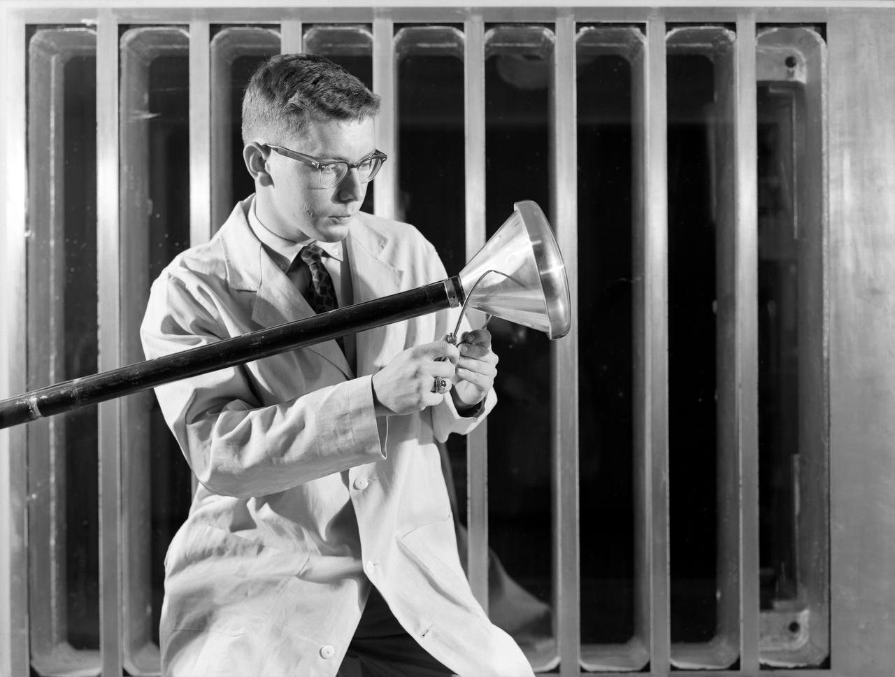 Researcher checks model of Project Fire Reentry package to be tested in Unitary Plan Wind Tunnel. Project FIRE (Flight Investigation Reentry Environment) studied the effects of reentry heating on spacecraft materials. It involved both wind tunnel and flight tests, although the majority were tests with Atlas rockets and recoverable reentry packages. These flight tests took place at Cape Canaveral in Florida. Wind tunnel tests were made in several Langley tunnels including the Unitary Plan Wind Tunnel, the 8-foot High-Temperature Tunnel and the 9x6-Foot Thermal Structures Tunnel.  Photo published in  book "A Century at Langley" by Joseph Chambers pg. 92 