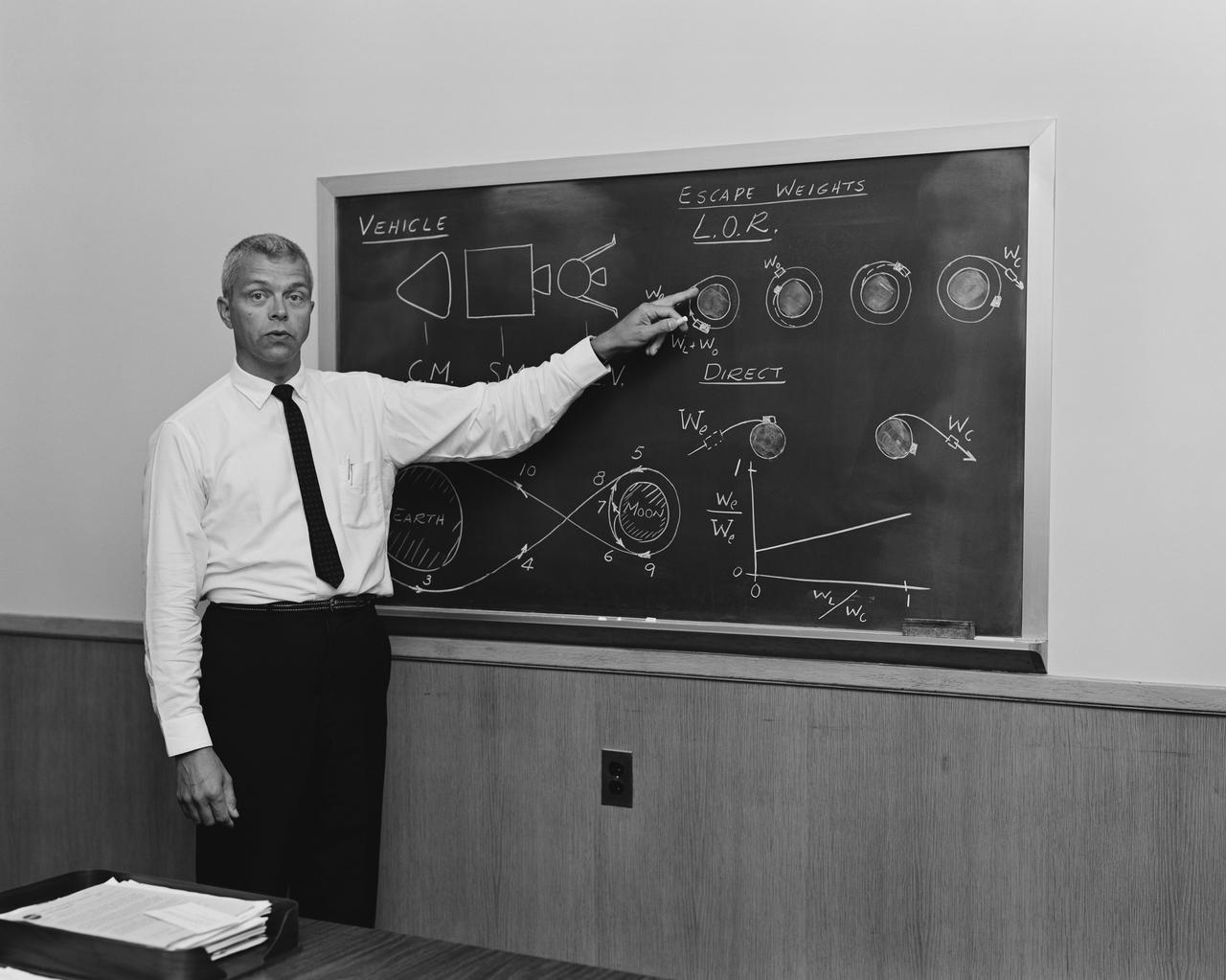 At blackboard, showing his space rendezvous concept for lunar landings. Lunar Orbital Rendezvous (LOR) would be used in the Apollo program. Photograph published in Space Flight Revolution - NASA Langley Research Center From Sputnik to Apollo (page 247), by James R. Hansen.