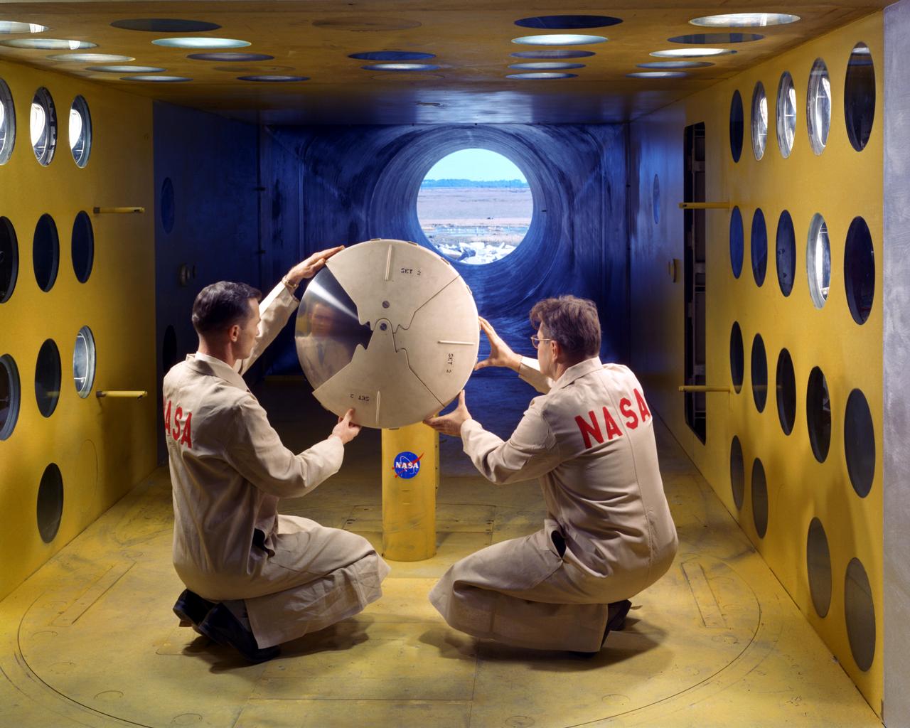 As part of the project FIRE study, technicians ready materials to be subjected to high temperatures that will simulate the effects of re-entry heating. Tests of various space capsule materials for Project FIRE were conducted. Photographed in the 9 X 6 Foot Thermal Structures Tunnel. Photograph published in Winds of Change, 75th Anniversary NASA publication, by James Schultz (page 78). Photograph also published in Engineer in Charge: A History of the Langley Aeronautical Laboratory, 1917-1958 by James R. Hansen (page 476).  Also Published in the book " A Century at Langley" by Joseph Chambers. Pg. 92