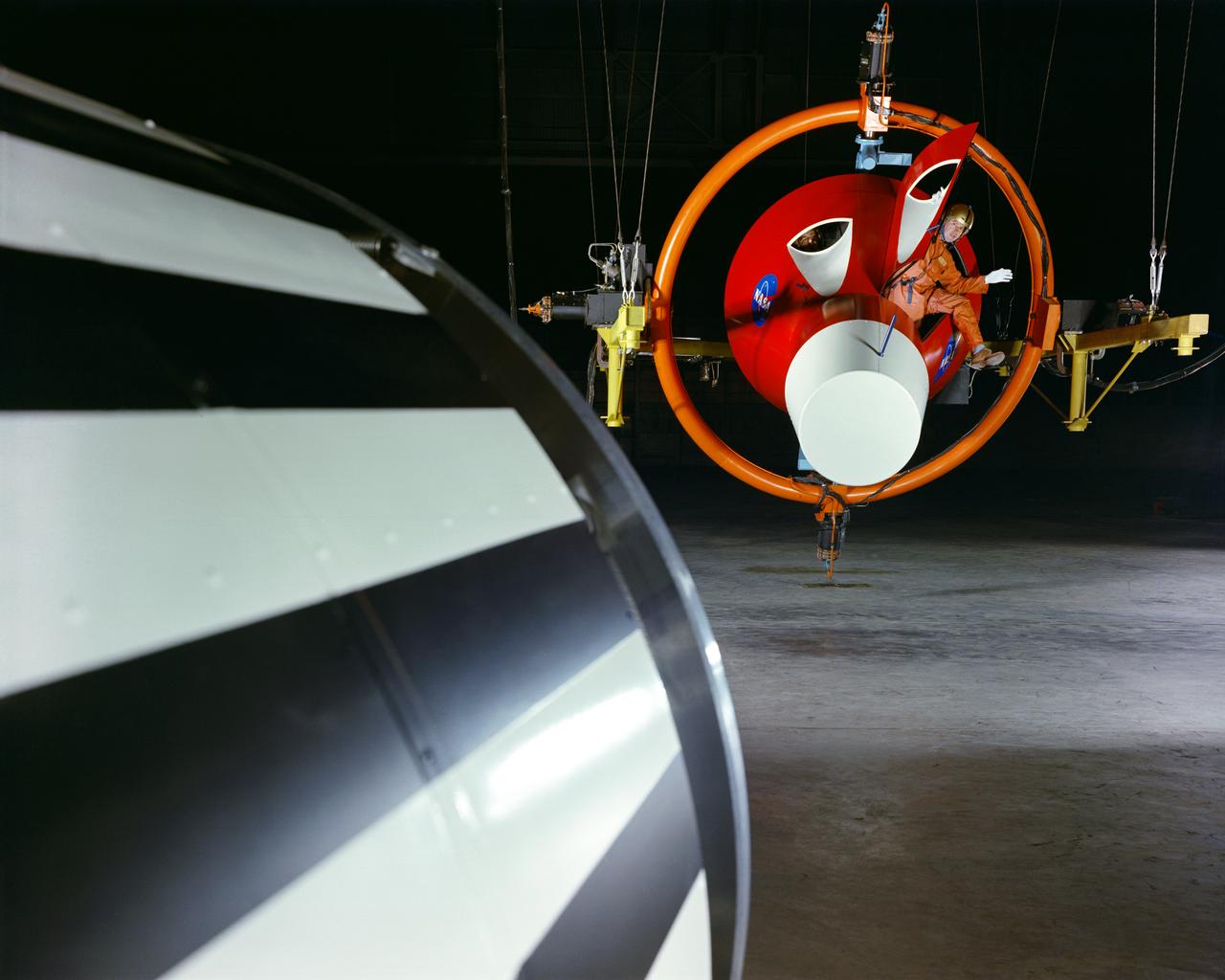Practicing with a full-scale model of the Gemini Capsule in Langley's Rendezvous Docking Simulator. -- Caption and photograph published in Winds of Change, 75th Anniversary NASA publication, (page 89), by James Schultz.
