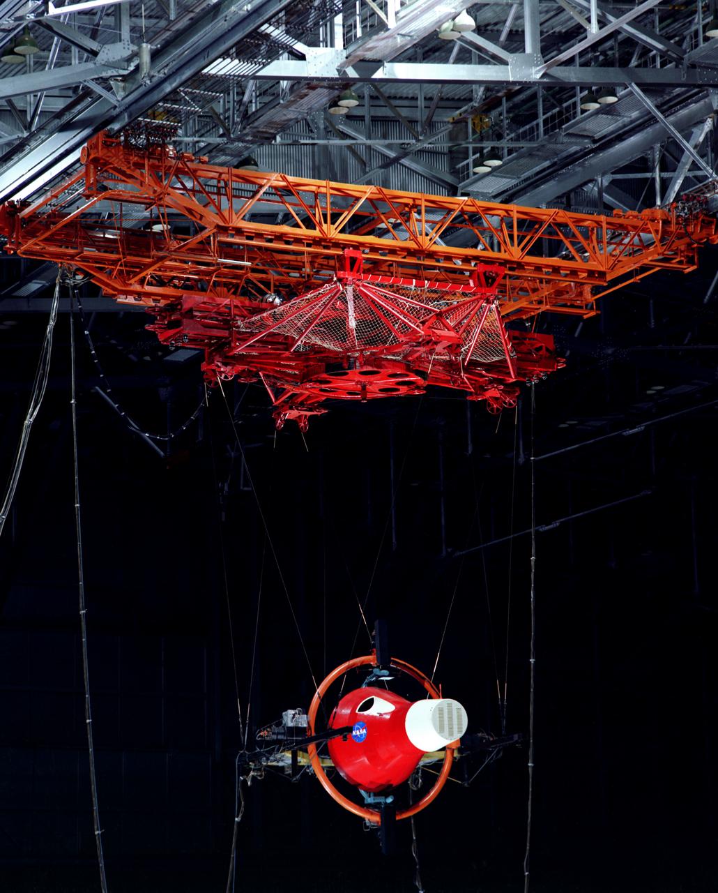 Gemini Rendezvous Docking Simulator suspended from the roof of the Langley Research Center s aircraft hangar. Francis B. Smith wrote: The rendezvous and docking operation of the Gemini spacecraft with the Agena and of the Apollo Command Module with the Lunar Excursion Module have been the subject of simulator studies for several years. This figure illustrates the Gemini-Agena rendezvous docking simulator at Langley. The Gemini spacecraft was supported in a gimbal system by an overhead crane and gantry arrangement which provided 6 degrees of freedom - roll, pitch, yaw, and translation in any direction - all controllable by the astronaut in the spacecraft. Here again the controls fed into a computer which in turn provided an input to the servos driving the spacecraft so that it responded to control motions in a manner which accurately simulated the Gemini spacecraft. -- Published in Barton C. Hacker and James M. Grimwood, On the Shoulders of Titans: A History of Project Gemini, NASA SP-4203 Francis B. Smith, Simulators for Manned Space Research, Paper presented at the 1966 IEEE International convention, March 21-25, 1966.