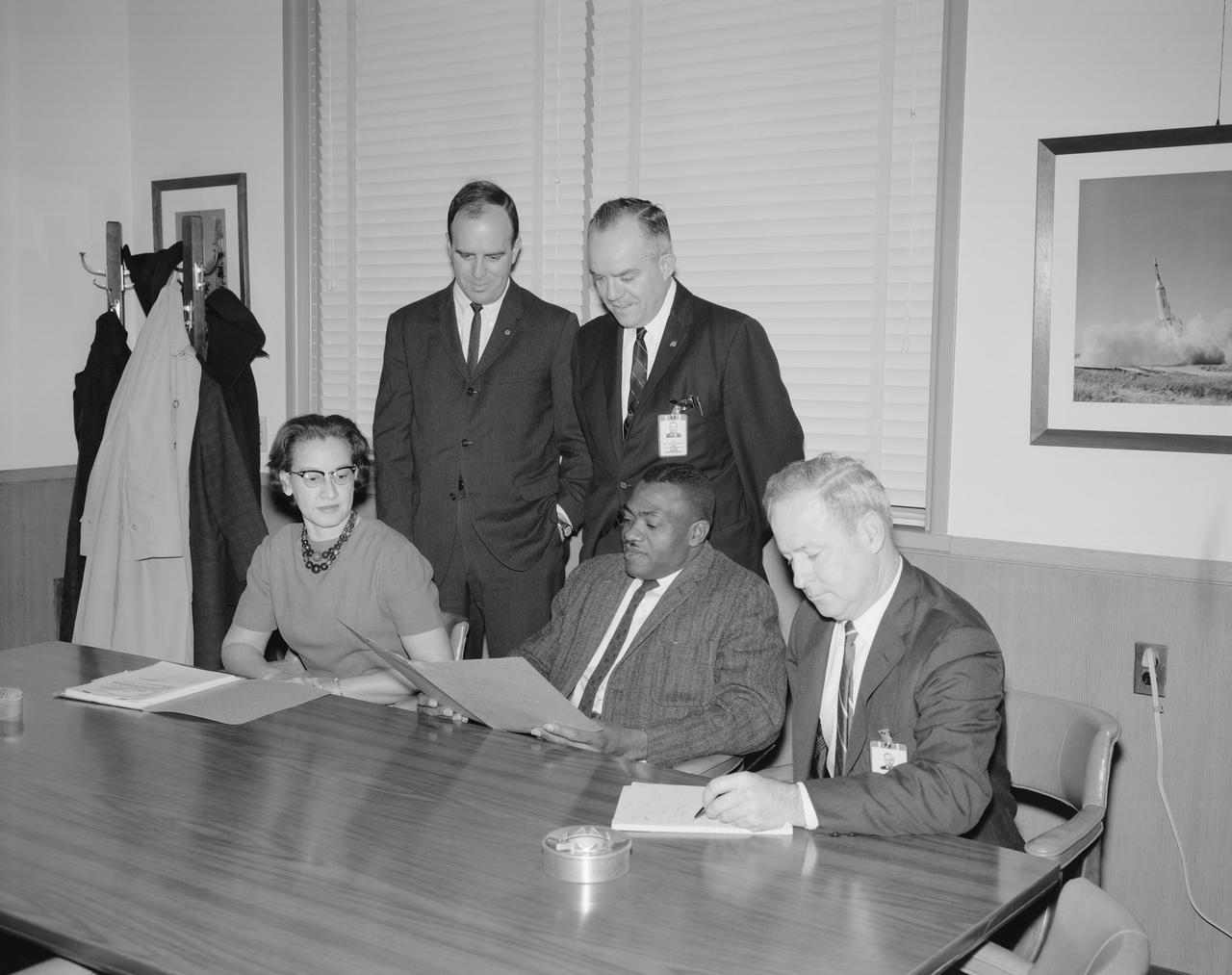 Seated from From Left: Katherine G Johnson, Lawrence W Brown, and J Norwood Evans, Employment Officer. Standing from Left: John J Cox, secretary; and Edward T Maher, chairman. Absent when picture was taken: Vernon S Courtney. Members are shown as they review the Center's Affirmative Action Program. The committee serves in an advisory capacity to the Personnel Division and Center management officials and seeks to explore realistic approaches to accomplishment of the objectives of the Affirmative Action program.