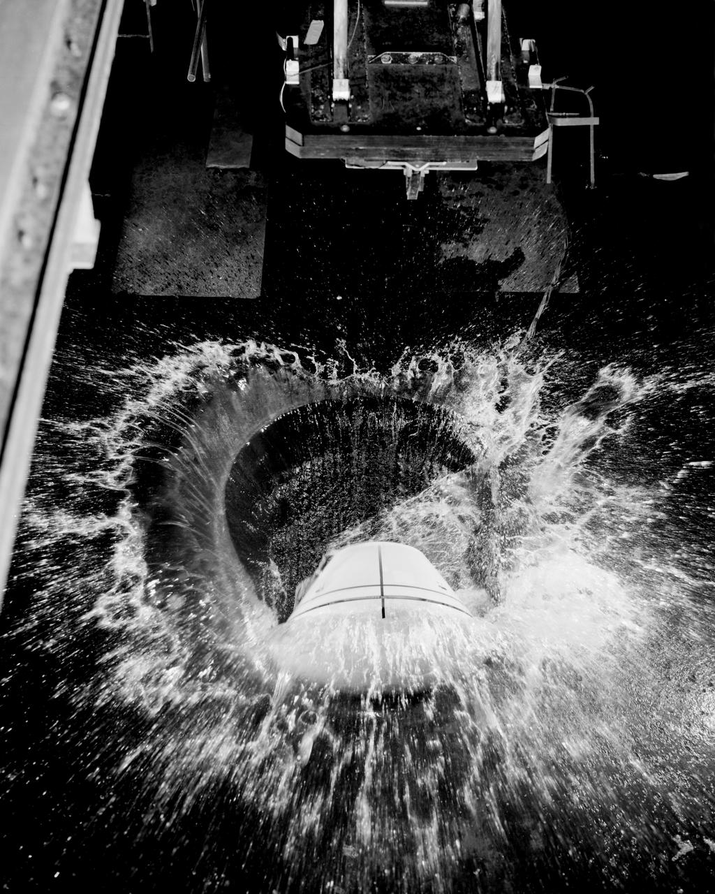 1/4th Scale Model of Apollo - Impact Structures Facility Launched from an overhead pendulum device, this Apollo spacecraft was tested in the Impact Structures Facility to determine water-landing characteristics. -- Photograph published in Winds of Change, 75th Anniversary NASA publication (page 91), by James Schultz.
