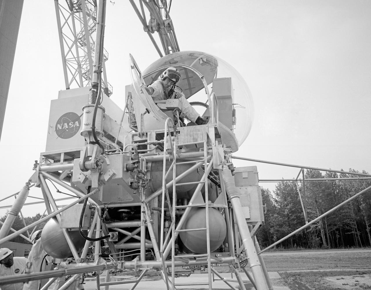 Astronaut Eugene Cernan at Lunar Lander Research Facility. Cernan under gantry, in training module.  Captain Cernan was one of fourteen astronauts selected by NASA in October 1963. On his second space flight, he was lunar module pilot of Apollo 10, May 18-26, 1969, the first comprehensive lunar-orbital qualification and verification flight test of an Apollo lunar module.