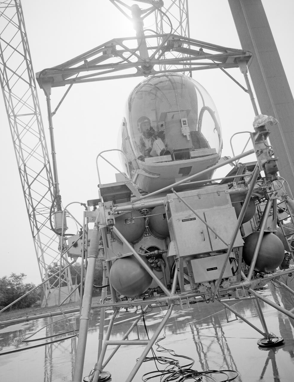 Astronaut Eugene Cernan at Lunar Lander Research Facility. Cernan under gantry, in training module.  Captain Cernan was one of fourteen astronauts selected by NASA in October 1963. On his second space flight, he was lunar module pilot of Apollo 10, May 18-26, 1969, the first comprehensive lunar-orbital qualification and verification flight test of an Apollo lunar module.