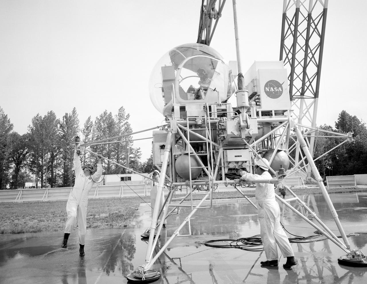 Astronaut Eugene Cernan at Lunar Lander Research Facility. Cernan under gantry, in training module.  Captain Cernan was one of fourteen astronauts selected by NASA in October 1963. On his second space flight, he was lunar module pilot of Apollo 10, May 18-26, 1969, the first comprehensive lunar-orbital qualification and verification flight test of an Apollo lunar module.