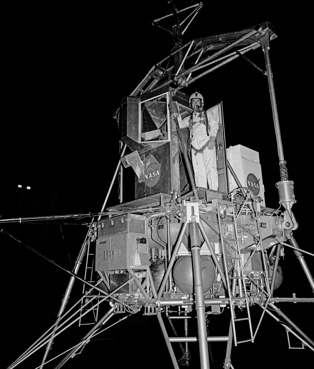Astronaut Fred Wallace Haise, Jr. at NASA Langley Lunar Research Facility, Gantry test at night. Haise was the lunar module pilot on Apollo 13 (April 11-17, 1970) and has logged 142 hours and 54 minutes in space.