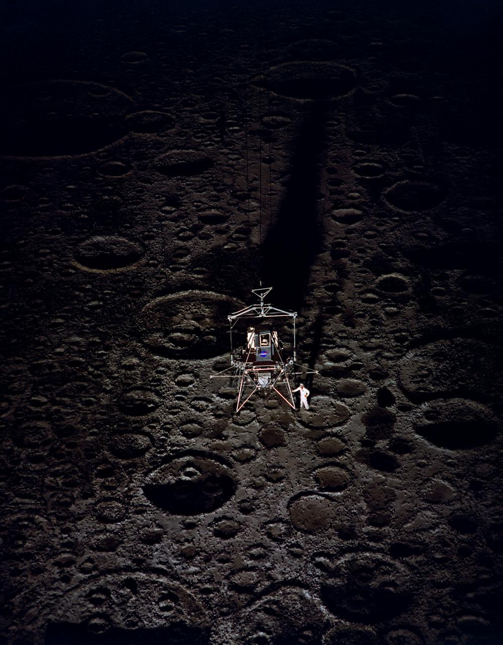 Lunar Landing Module photographed at night at the Lunar Landing Research Facility. Gantry facility 1297.  Upright cockpit design lander over  moonscape  pavement at LLRF. 69-4872 was published in Winds of Change, 75th Anniversary Publication of NASA, P.88, by James Schultz.