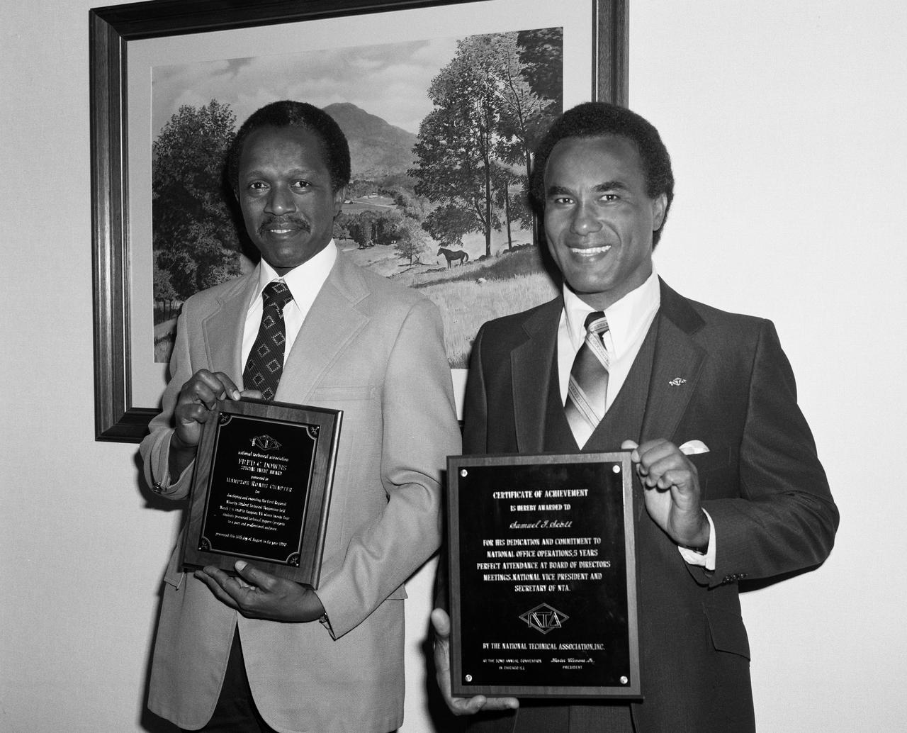 From left to right; Gilbert A. Haynes holding the NTA Fred C. Downs Special Event Award  and Samuel J. Scott with award for their participation in the local Hampton Roads Chapter of the (NTA) National Technical Association.  The guidance and counseling of minority youth is one of NTA's prime objectives. Formed in 1925, NTA has 15 chapters comprised of architects,engineers, scientists, and educators. NTA activities are directed toward encouraging and assisting public and private institutions in identifying potential minority technical talent.