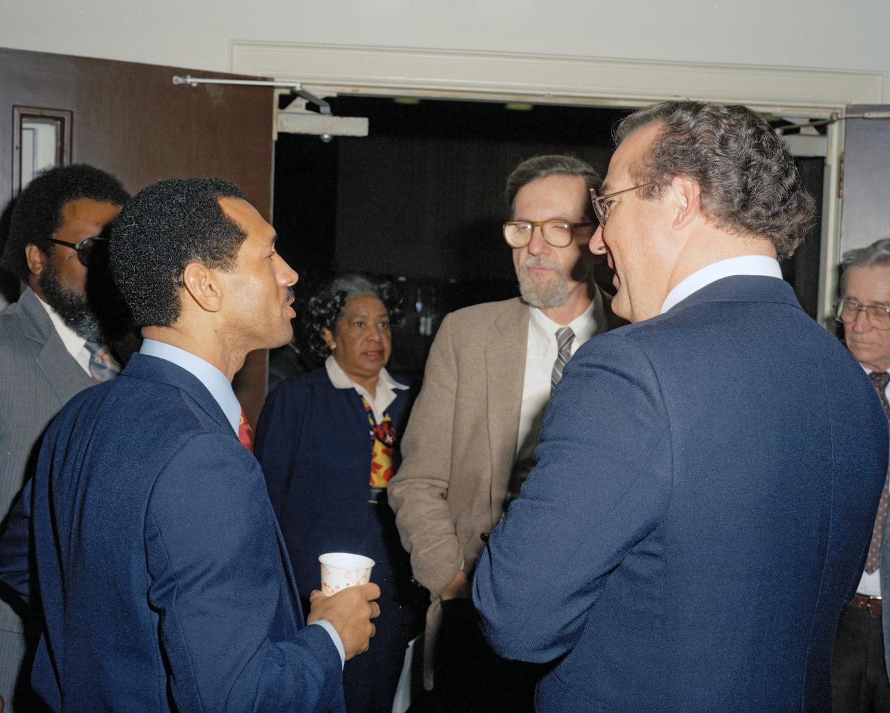 Photograph taken November 8, 1984.  Student Symposium Meeting  Mary Jackson in background.  Both Mary Jackson and Katherine Johnson are women featured in the book Hidden Figures, by Margot Lee Shetterly.  Man facing camera with glasses is center director Dr. Donald Hearth.