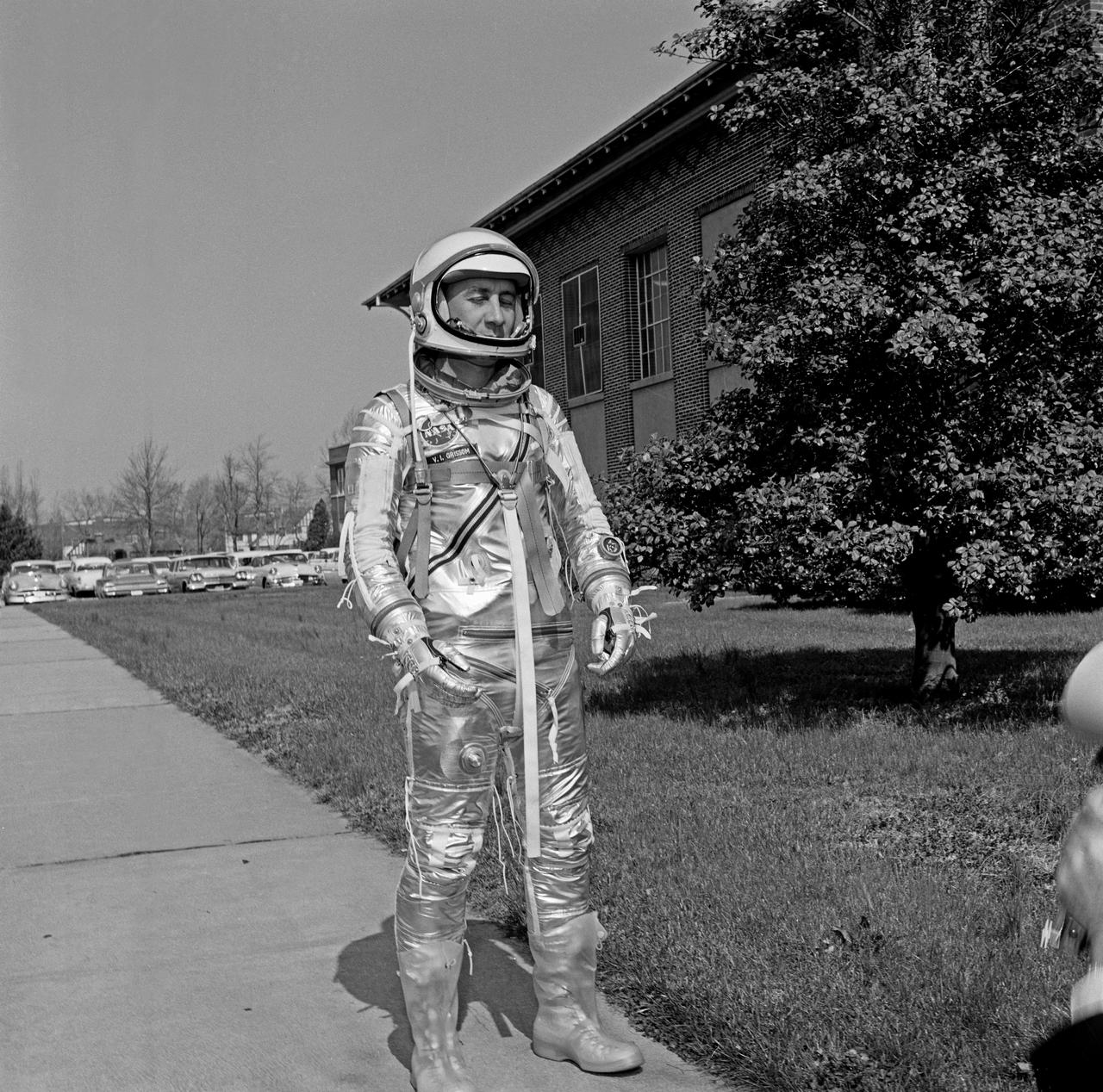 Gus Grissom trying on a Spacesuit; Seated with assistant; Seated with assistant putting on boots; Standing by mirror, name tag visible; Outside in suit, name tag visible. Mercury Project photo, 1961. Original negatives sent to Johnson Space Center when astronauts moved to that center.  Photograph take on 03/27/1961.