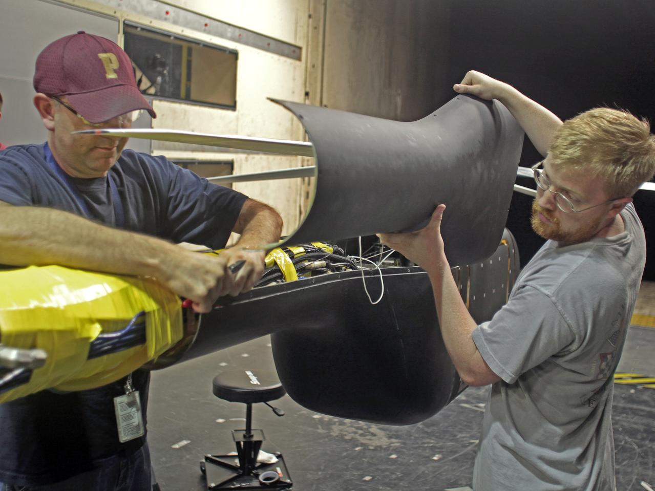 Helicopter active flow control tests in the 14X22 subsonic wind tunnel. Photos include preparation of the model before testing and the control room where testing is monitored and data collected