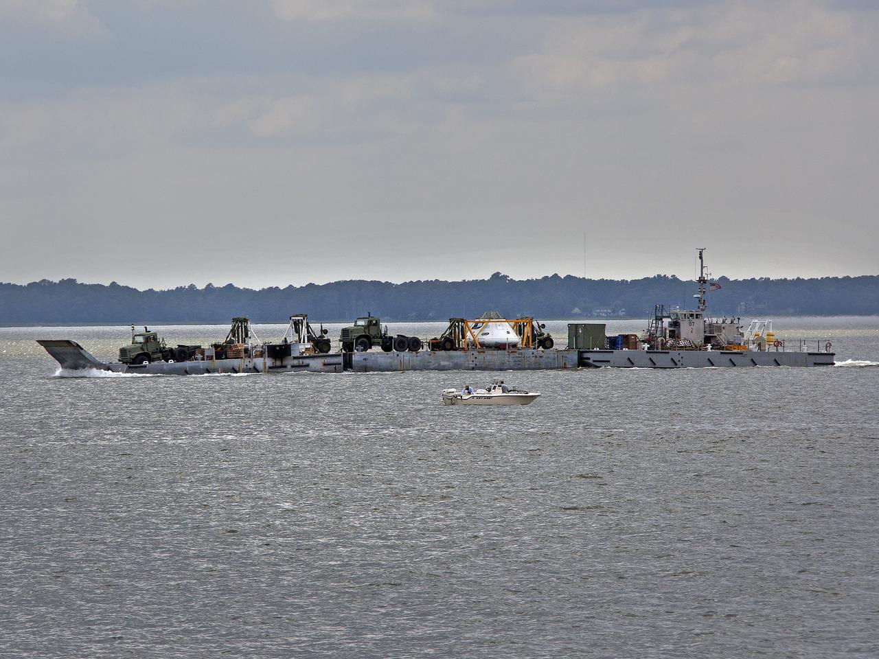 The Orion Test Capsule and a number of other items used in the capsule recovery at being transported down the James River on a Navy INLS "Improved Navy Lighterage System" from Fort Eustis from where it was loaded. Its liquid route will take them to Little Creek Amphibious Base in Norfolk, where it will stay until scheduled recovery test will be performed. 