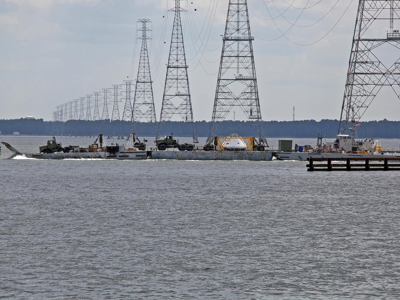 The Orion Test Capsule and a number of other items used in the capsule recovery at being transported down the James River on a Navy INLS "Improved Navy Lighterage System" from Fort Eustis from where it was loaded. Its liquid route will take them to Little Creek Amphibious Base in Norfolk, where it will stay until scheduled recovery test will be performed. 