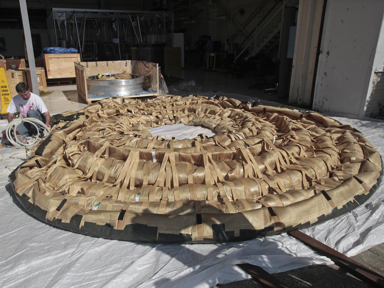 The HIAD stands for Hypersonic Inflatable Aerodynamic Decelerator, an inflatable spacecraft technology that allows payloads to survive the harsh conditions of atmospheric re-entry. This photo was taken at  NASA Langley in Building 1250 when sensors were being applied.