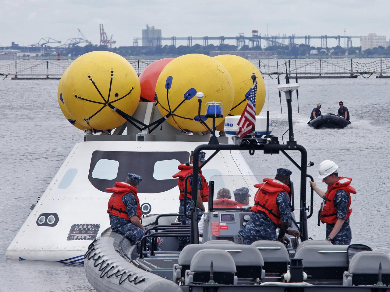 On August 15, 2013, at the Naval Station Norfolk near NASA’s Langley Research Center in Virginia, NASA and the U.S. Navy conducted a stationary recovery test on the Orion boilerplate test article in the water near a U.S. Navy ship. NASA and the U.S. Navy are conducting tests to prepare for recovery of the Orion crew module and forward bay cover on its return from a deep space mission. The stationary recovery tests allow the teams to demonstrate and evaluate the recovery processes, the hardware and the test personnel in a controlled environment. During the test, the U.S Navy Dive Team checked the capsule for hazards while sailors from the USS Arlington approached the capsule in inflatable boats, and towed it back to the ship’s flooded well deck. A second test will be conducted next year in the open waters of the Pacific Ocean.
