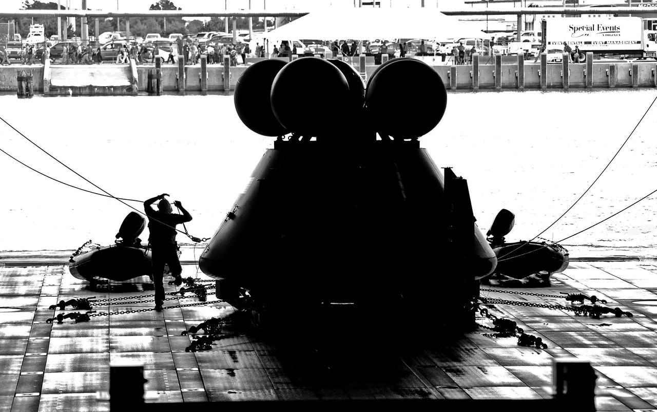 On August 15, 2013, at the Naval Station Norfolk near NASA’s Langley Research Center in Virginia, NASA and the U.S. Navy conducted a stationary recovery test on the Orion boilerplate test article in the water near a U.S. Navy ship. NASA and the U.S. Navy are conducting tests to prepare for recovery of the Orion crew module and forward bay cover on its return from a deep space mission. The stationary recovery tests allow the teams to demonstrate and evaluate the recovery processes, the hardware and the test personnel in a controlled environment. During the test, the U.S Navy Dive Team checked the capsule for hazards while sailors from the USS Arlington approached the capsule in inflatable boats, and towed it back to the ship’s flooded well deck. A second test will be conducted next year in the open waters of the Pacific Ocean.