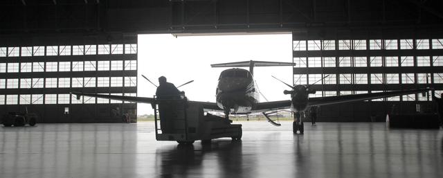 The NASA Langley's twin-engine turboprop, Beechcraft King Air B200 aircraft is towed through the large doors and inside the hangar of the Research Center, Building 1244.