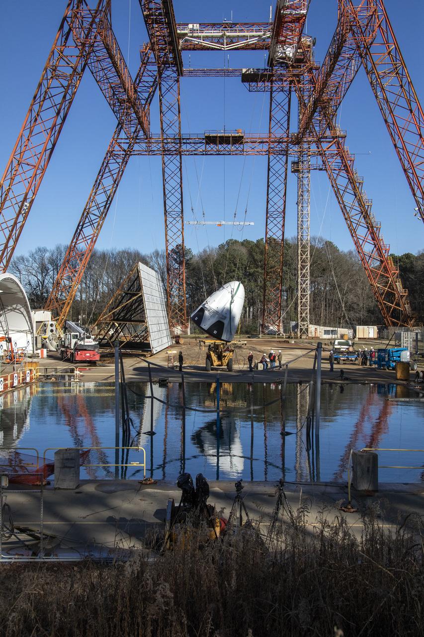 The Space X capsule being tested at NASA Langley’s Splash Test Basin.  A series of drop tests into the Hydro Impact Basin at the Landing and Impact Research Facility at NASA’s Langley Research Center in Hampton, Virginia helped SpaceX’s Crew Dragon capsule prepare to safely land astronauts. A mock-up of the capsule with two instrumented crash test devices seated inside was tested in March 2019, representing how the capsule may impact the water during splashdown with different wind and parachute dynamics. Data collected helps understand pressures on the capsule and how those forces affect the spacecraft and occupants. Crew Dragon will carry NASA astronauts Bob Behnken and Doug Hurley to the International Space Station in the Demo-2 mission, the final SpaceX flight test for NASA’s Commercial Crew Program and the first flight of astronauts to orbit from U.S. soil since the space shuttle’s retirement in 2011. (NASA/ David C. Bowman)