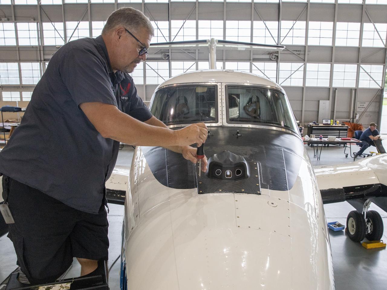 Aircraft mechanic C. Garber working on the camera housing to be tested for the flight display for the X59.