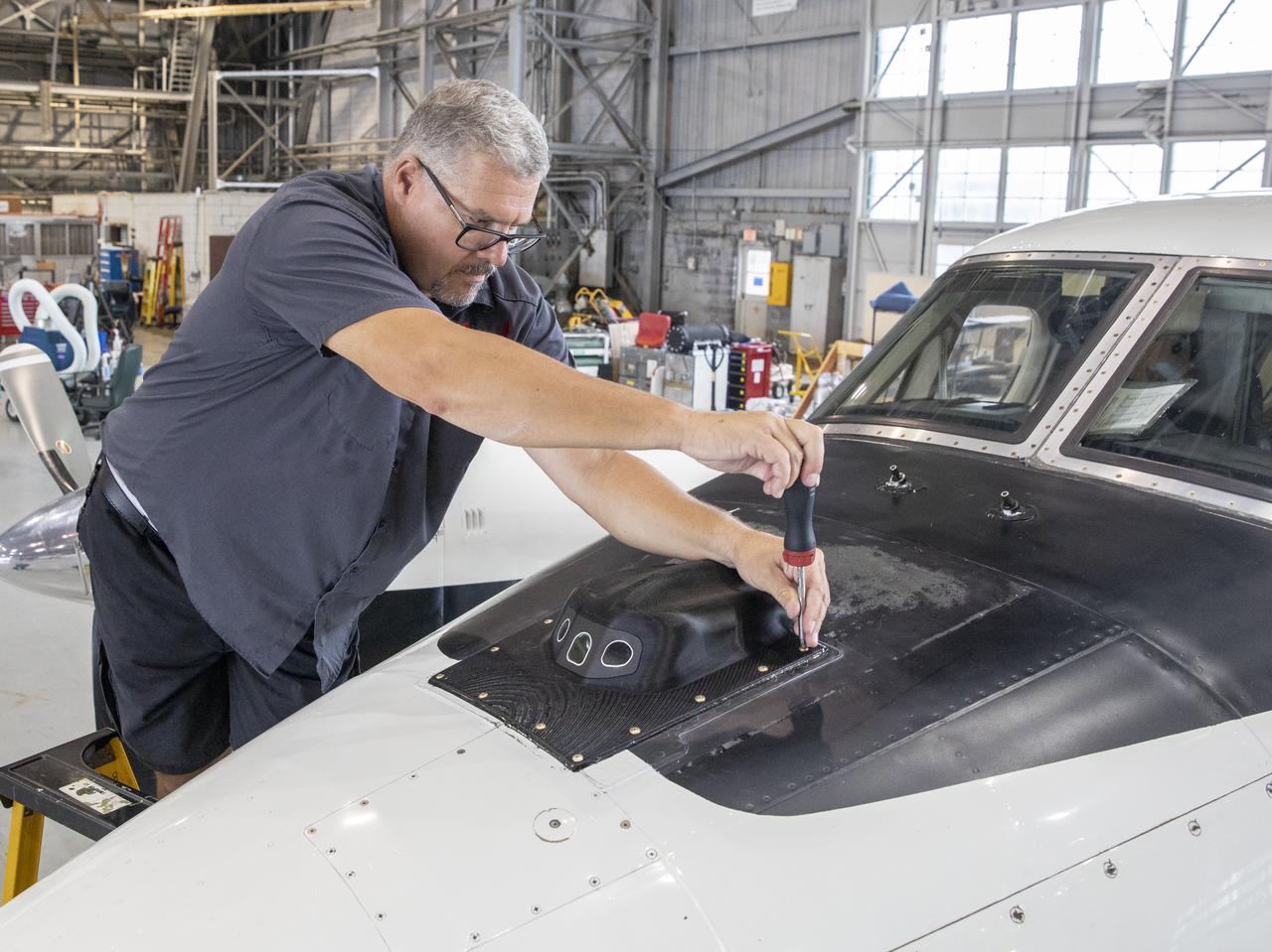 Aircraft mechanic C. Garber working on the camera housing for the flight display for the X59 to tested on the B200 King Air.