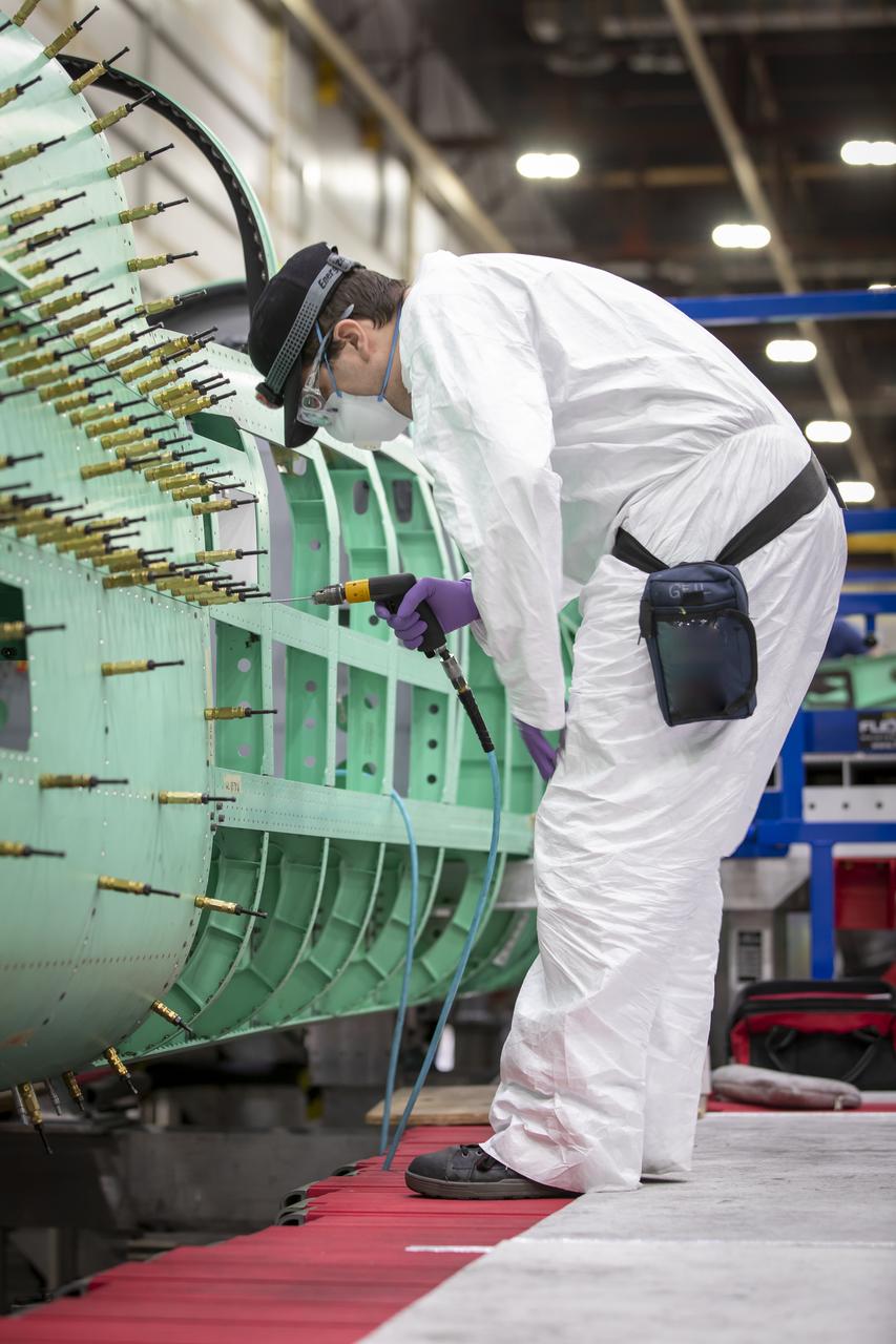 Event: SEG 210 Forebody A Lockheed Martin technician prepares to install the left fuselage skins onto the X-59. Once in the air, the aircraft, currently under construction at Lockheed Martin Skunk Works in Palmdale, California, will demonstrate the ability to fly supersonic while reducing the loud sonic boom to a quiet sonic thump.