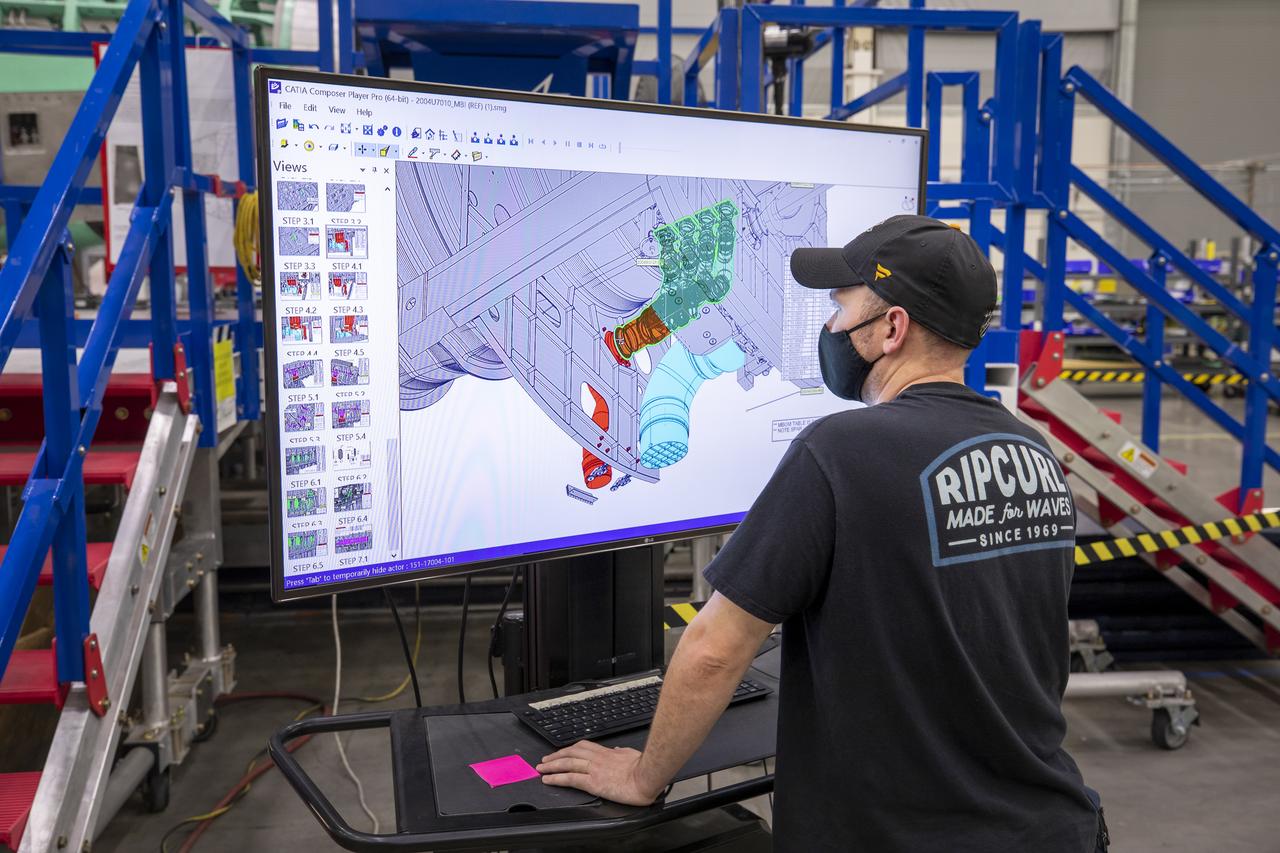 A Lockheed Martin technician looks at the connector installation on the cad model of the X-59 airplane. The aircraft, under construction at Lockheed Martin Skunk Works in Palmdale, California, will demonstrate the ability to fly supersonic while reducing the loud sonic boom to a quiet sonic thump.