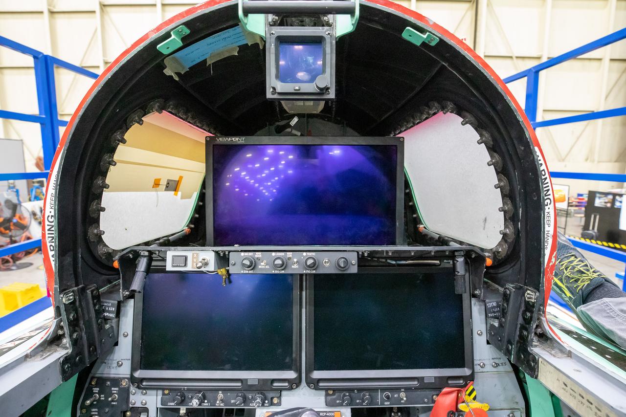 This image shows the forward view of the X-59’s cockpit with the canopy open. The aircraft will not have a forward-facing window and will use an eXternal Vision System (XVS) made up of a high definition 4K monitor (located in the center) and two monitors below to help the pilots safely fly through the skies. 