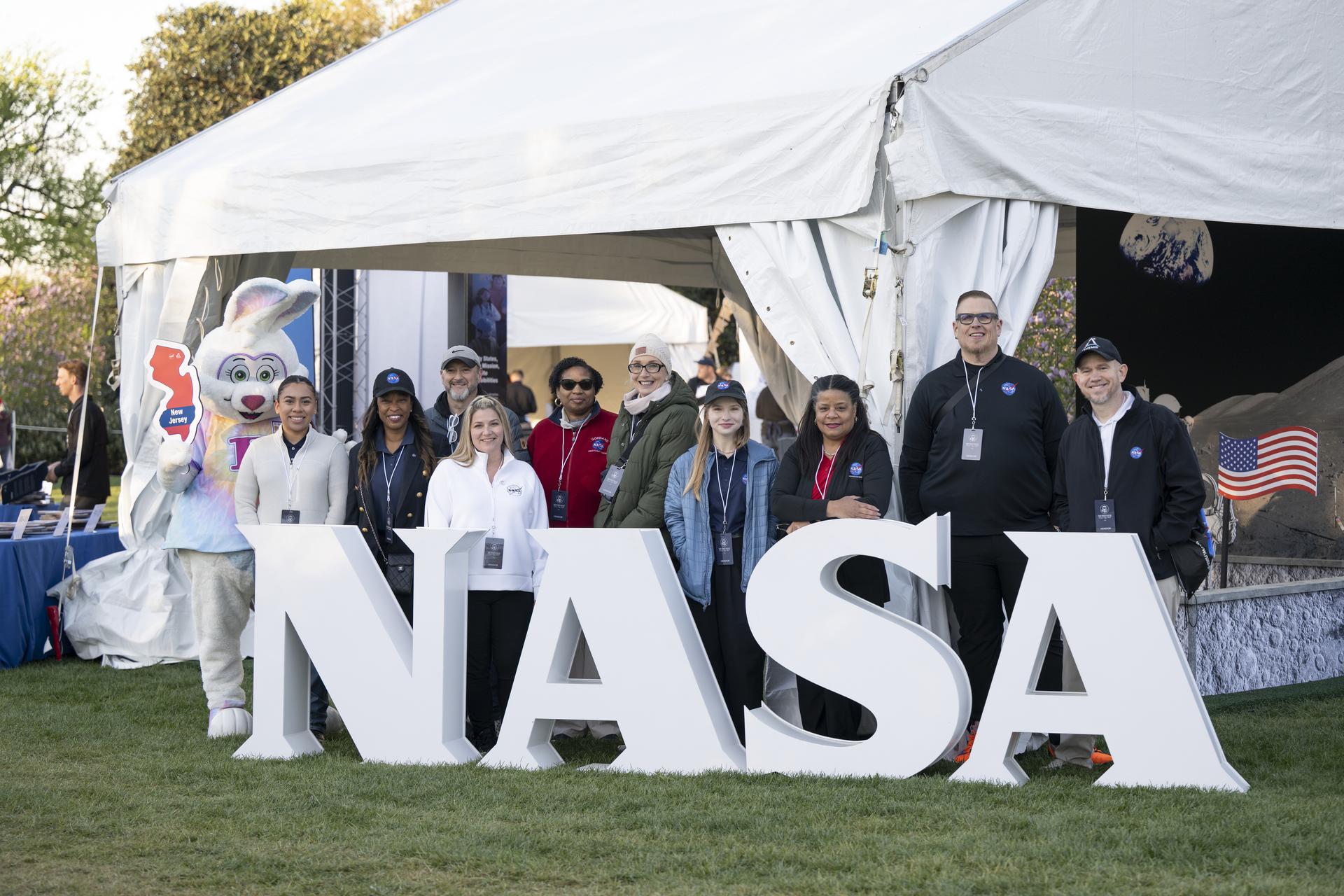 NASA staff from left to right, Keiry Martinez, Lisa Frazier, Dustin Hitt, Kathryn Gulledge, Holly Miller, Rachel Zasucha, Denise Young, Jason Smith, Brian Campbell, and Trena Ferrell pose with the Easter Bunny at the NASA Letters before the start of the White House Easter Egg Roll, on the South Lawn in Washington D.C., on April 6, 2026. (Photo Credit: (NASA/Crystal R. Hines)