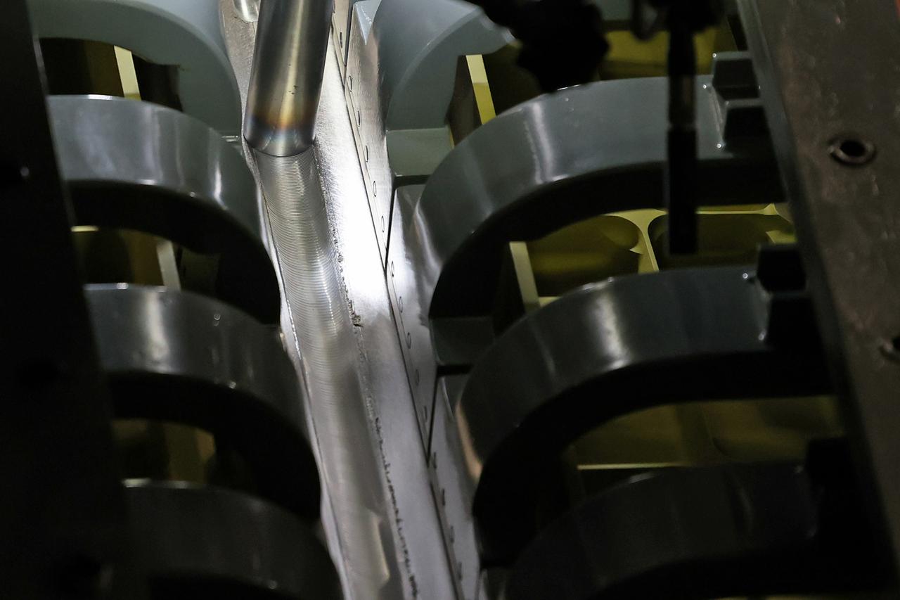 At NASA’s Michoud Assembly Facility in New Orleans, technicians from Orion prime contractor Lockheed Martin have welded together three cone-shaped panels on Orion’s crew module for the Artemis III mission that will land the first woman and next man on the Moon. The crew module’s primary structure, the pressure vessel, is comprised of seven machined aluminum alloy pieces that are welded together through a weld process that produces a strong, air-tight habitable space for astronauts during the mission. The pressure vessel is designed to withstand the harsh and demanding environment of deep space, and is the core structure upon which all the other elements of Orion’s crew module are integrated. Infographic showing the seven pieces of Orion's underlying structure With welding complete on the crew module cone panels – one of which contains windows providing astronauts views of the Moon and Earth – work will begin joining the forward bulkhead to the tunnel to create the top of the spacecraft, followed by the barrel and aft bulkhead join to form the bottom of Orion. Last, the forward bulkhead will be welded to the top of the panels and, for the seventh and closeout weld, the bottom of the cone panels will be joined to the barrel to complete the pressure vessel. Once welding of the Artemis III crew module primary structure is complete, it will be shipped to NASA’s Kennedy Space Center in Florida where it will undergo further assembly beginning this fall. Orion, the Space Launch System, and Exploration Ground Systems programs are foundational elements of the Artemis program. Artemis I will be the first integrated flight test of Orion and SLS and is targeted to launch later this year. Artemis II will follow and is the first crewed mission, taking humans farther into space than ever before. Image credit: NASA/Michael DeMocker